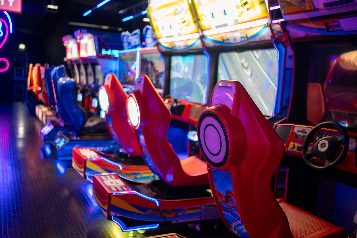 Empty red gaming chairs in illuminated arcade game zone