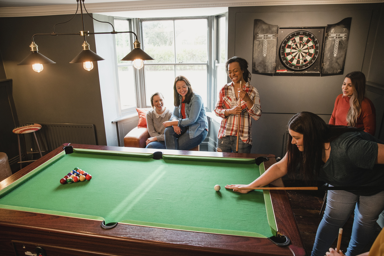 Small group of friends playing pool in a games room