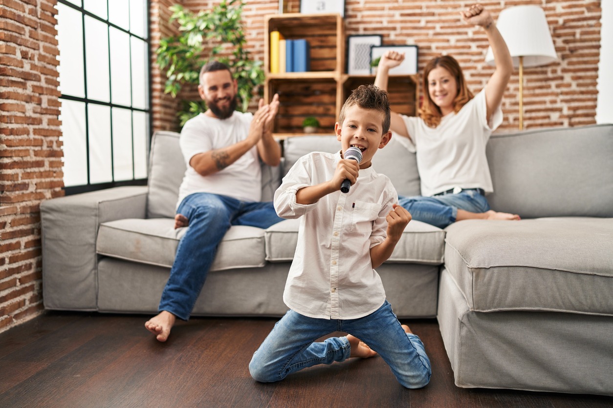 A boy singing courageously with his parents
