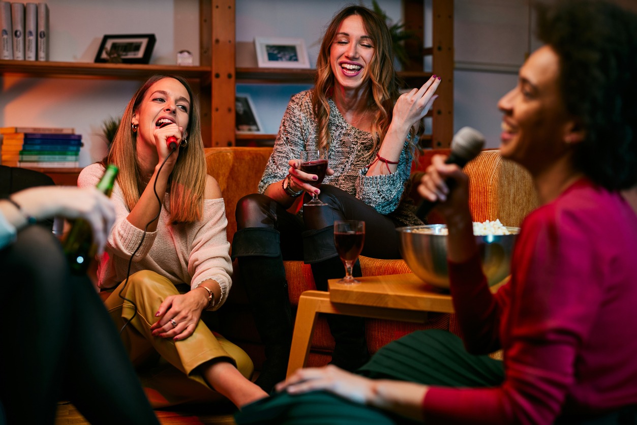 Groups of friends happily singing karaoke
