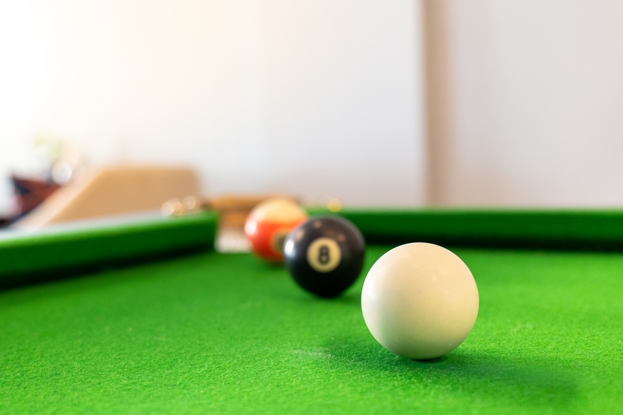 three balls perfectly aligned into a pocket of a pool table