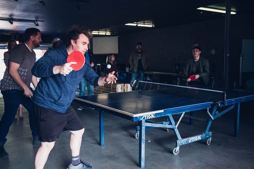 men using a Stiga ping pong table