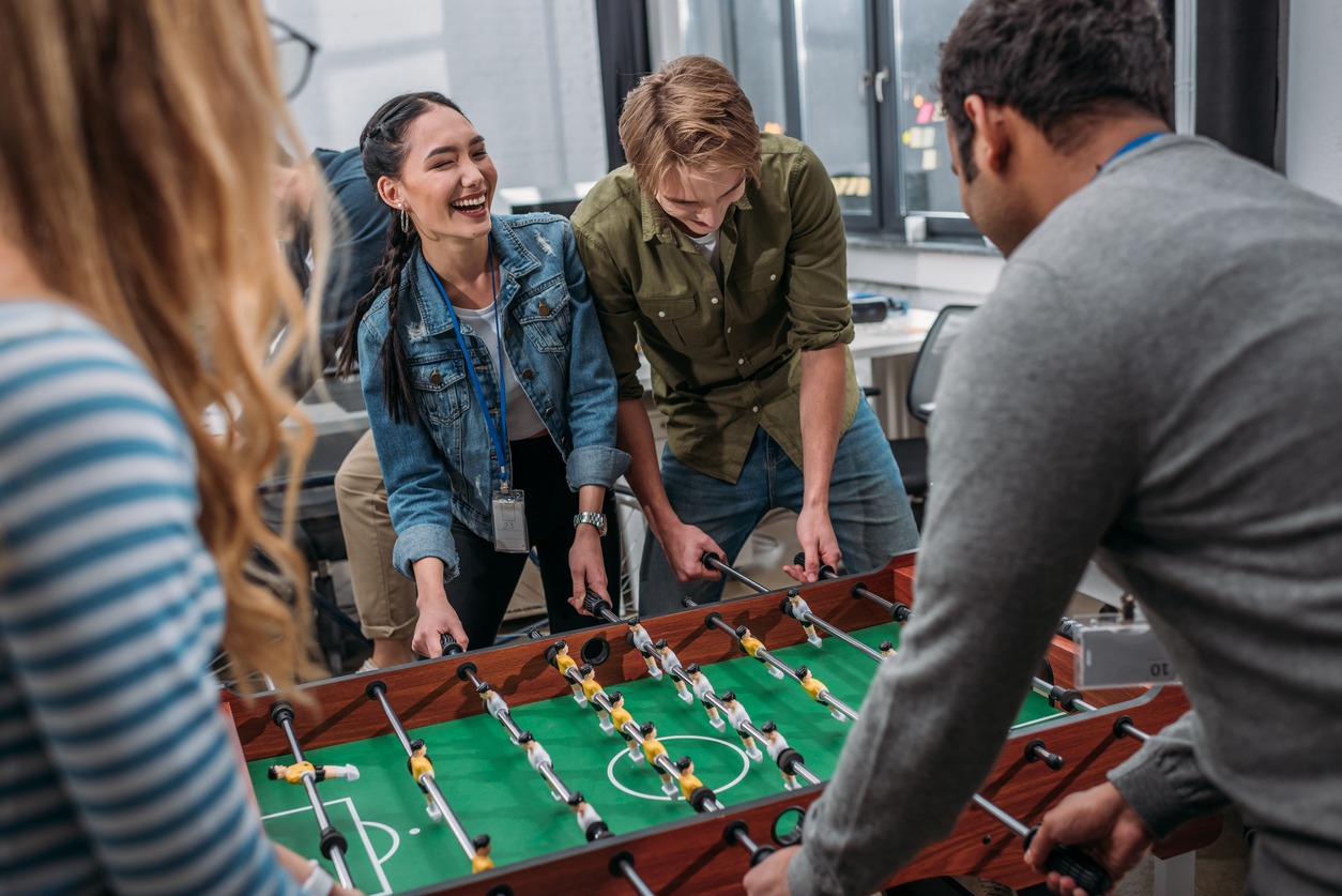 A group of friends cheerfully playing foosball together