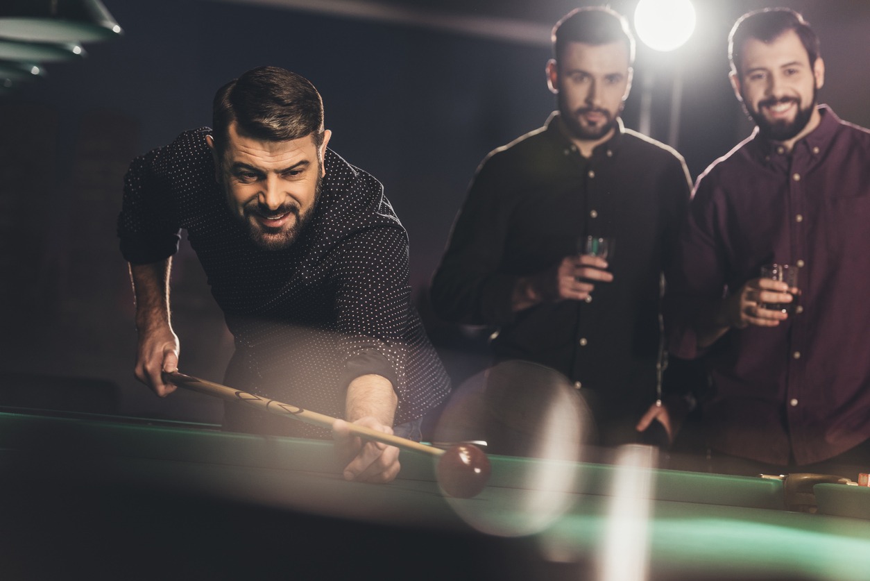 A group of smartly dressed men playing billiards