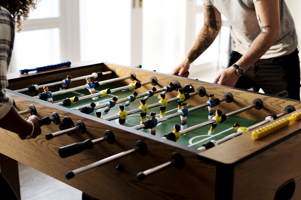 players at a  wooden foosball table